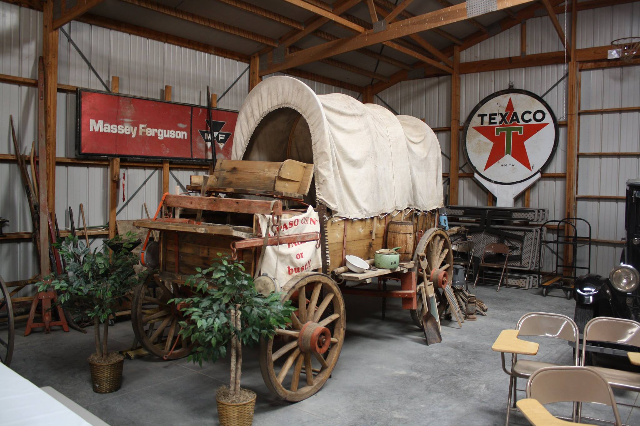 pioneer wagon with canvas cover displaying tools and implements used on journey and for new homestead when they arrived