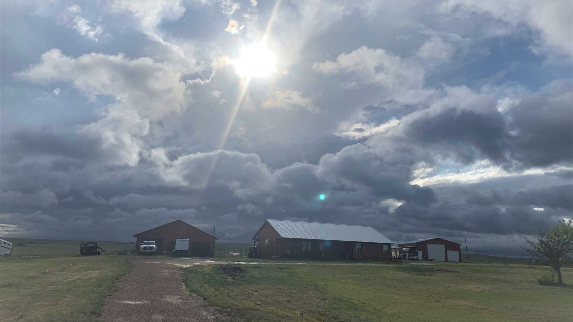 afternoon sun breaks through storm clouds in early spring at our ranch